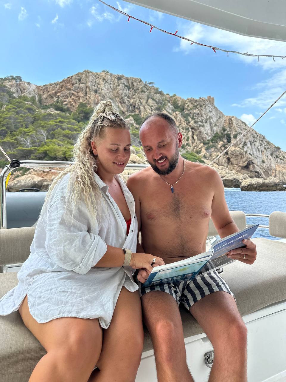 Roman and Ana reading together on the catamaran deck